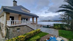 a house with a balcony with a view of the water at Playa de Comillas in Comillas