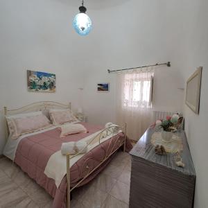 a bedroom with a bed and a table at Trulli di Rosa in Locorotondo