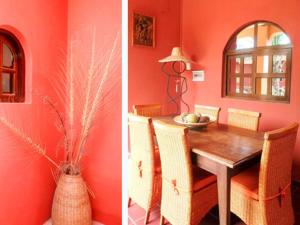 uma sala de jantar com paredes cor de laranja e uma mesa com cadeiras em Keryvonne em Lomé