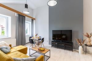 a living room with a couch and a television at Apartment Quiet Street 11/7E in Oświęcim +5 photos