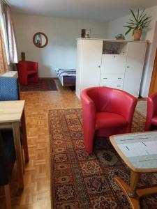 un soggiorno con tavolo e sedia rossa di Das Schweizer Haus a Sarnen