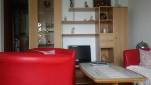 ein Wohnzimmer mit einem Tisch und 2 roten Stühlen in der Unterkunft Josy's Holiday & Business Apartment in Sarnen