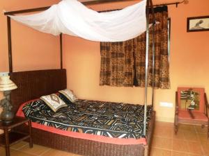 sypialnia z łóżkiem z baldachimem w obiekcie Keryvonne w mieście Lomé