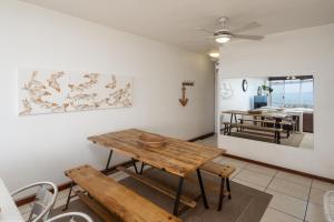 a dining room with a wooden table and benches at 63 Sea Lodge - by Stay in Umhlanga in Durban