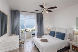 a bedroom with a bed and a ceiling fan at 63 Sea Lodge - by Stay in Umhlanga in Durban +24 photos