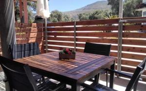 Ein Holztisch mit einer Topfpflanze auf einer Terrasse in der Unterkunft Elaion Apartments in Kántanos