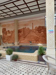 una piscina en un edificio con una pintura en la pared en Hotel Shams, en Bukhara