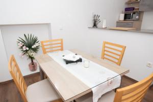 a dining room table with chairs and a white counter at Apartments Šentvid in Ljubljana