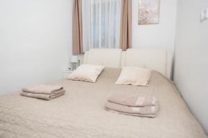 ein Schlafzimmer mit einem Bett mit zwei Kissen darauf in der Unterkunft Apartments Šentvid in Ljubljana