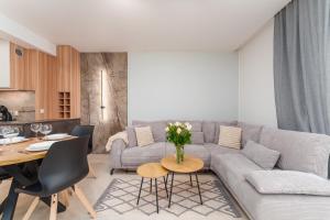 un soggiorno con un divano grigio e un tavolo di RICAR Apartament Klifowa Rewal a Rewal Altre 30 foto