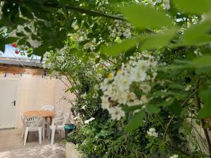 a patio with a table and chairs and flowers at L'APPARTEMENT BOULONNAIS in Boulogne-sur-Mer