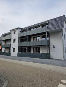 un grand bâtiment blanc avec un toit noir dans l'établissement Eibauer Apartments, à Sinsheim