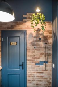 a hallway with a blue door and a brick wall at Casa Verde - Brasov Homes in Braşov