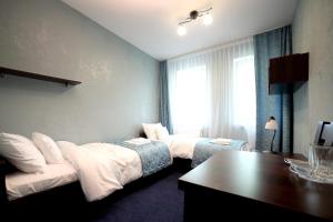 a hotel room with two beds and a desk at Zajazd Monki in Mońki