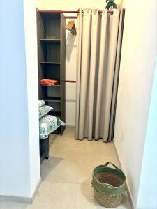 a walk in closet with a shower curtain and a basket at Manapany and Rose in Le Butor