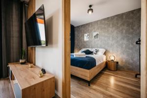 a bedroom with a bed and a wooden table at Apartamenty Krakowska 24 z ogródkiem in Ostrów Wielkopolski