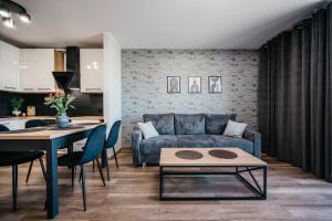 a living room with a couch and a table at Apartamenty Krakowska 24 z ogródkiem in Ostrów Wielkopolski