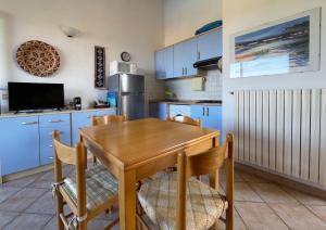 a kitchen with a wooden table and blue cabinets at Gallura da Cino in Badesi