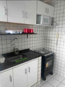 una cocina con fregadero y microondas en Apartamento no Derby, en Recife