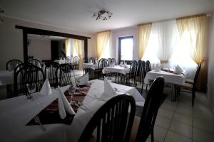 a restaurant with tables and chairs with white table cloth at Zajazd Monki in Mońki