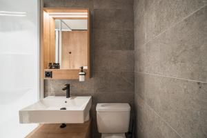 サン・ベルナルディーノにあるHotel Brocco & Postaのバスルーム(洗面台、トイレ、鏡付)