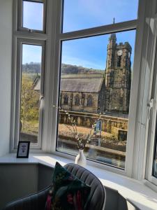 a room with a window with a view of a church at Modern River View Mytholmroyd Apartment in Mytholmroyd