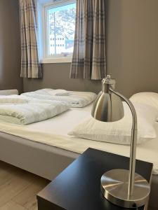 1 dormitorio con 2 camas y una lámpara en una mesa en Birkelunden Bed & Breakfast en Rjukan