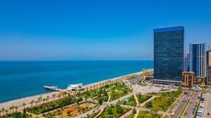 una ciudad con un edificio alto junto al océano en Orbi Beach Tower, en Batumi