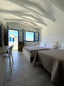 una camera con 2 letti, una scrivania e una finestra di Aldiva Chalet a Torvaianica