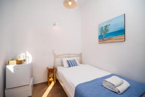 a bedroom with a bed and a painting on the wall at Babis & Popi Rooms and Studios in Frangokastello