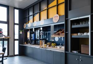 a restaurant with a counter with a shelf of food at B&B HOTEL Grenoble Centre Verlaine in Grenoble
