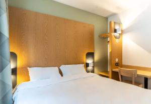 - une chambre avec un grand lit blanc et un bureau dans l'établissement B&B HOTEL Aix-en-Provence Le Tholonet, à Aix-en-Provence