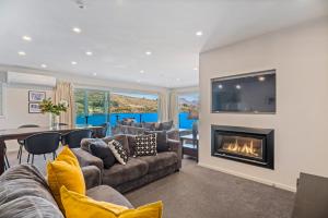 a living room with a couch and a fireplace at Lakefront Penthouse Apartment with 270-degree view in Queenstown