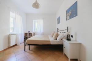 a bedroom with a bed in a white room at Villa Chiara Porto Recanati in Porto Recanati