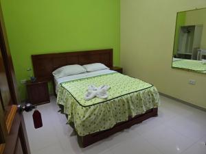 a bedroom with a bed with a bow on it at Hospedaje Paraíso in Tingo María