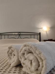 uma pilha de toalhas brancas numa cama em Sidra Hotel em Hydra
