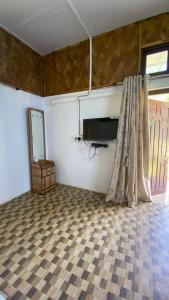 Habitación con TV y suelo a cuadros. en TULDA BAMBUSA RESORT, en Kāziranga