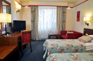 a hotel room with two beds and a television at Ahotel in Czechowice-Dziedzice