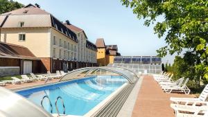 a swimming pool with lounge chairs next to a building at VitaPark Sonyachnyy Provans in Satanov