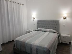 een slaapkamer met een groot bed en 2 nachtkastjes bij Hostel Boutique Marisol in Monte Gordo