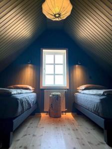 a attic room with two beds and a window at Skard Cottages in Fludir +106 photos