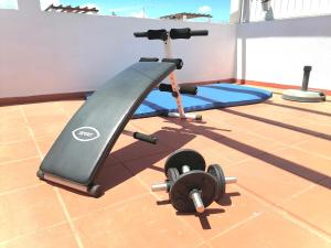 a gym with a treadmill and weights on a floor at Marreiro's house Algarve - Child friendy - Private Pool in Lagos