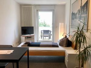 Cette chambre comprend un lit, une table et une fenêtre. dans l'établissement Ferienwohnungen und Apartmenthaus Halle Saale - Villa Mathilda, à Halle-sur-Saale