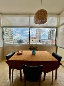 a dining room table with chairs and a large window at Apartamento a pasos de todo. in Punta del Este