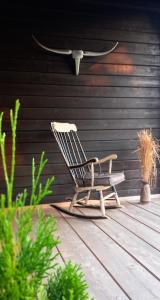 uma cadeira de baloiço sentada num deque de madeira em Chalet Wickie em Grafenau