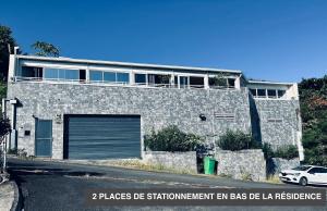 a stone house with a car parked in front of it at Vaste chambre vue mer montagne Ti Kaz Miyou 3 in La Possession