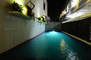 a pool of blue water in an alley at night at Gecko Hostel in Siem Reap