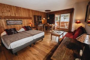 - une chambre avec un lit et un salon dans l'établissement Residence Hôtelière La Renardiere, à Samoëns