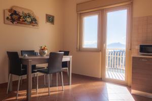 una sala da pranzo con tavolo e sedie e un balcone di casavacanzabordonaro a Palermo