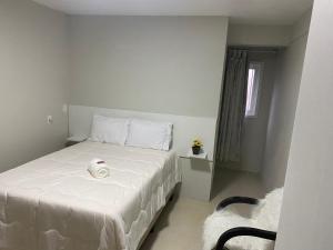 a bedroom with a bed with a white sheets and a window at Pousada Le Sorelle ap04 in Rosário do Sul